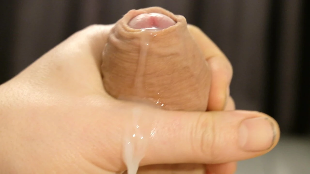 Cumshot very close up man wanks uncut erect cock cumming covering hand and penis with cum in selfie