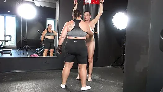 Herrin april praktiziert das boxen auf einem menschlichen boxsack.