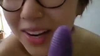 Senhora asiática esfrega sua boceta com um brinquedo