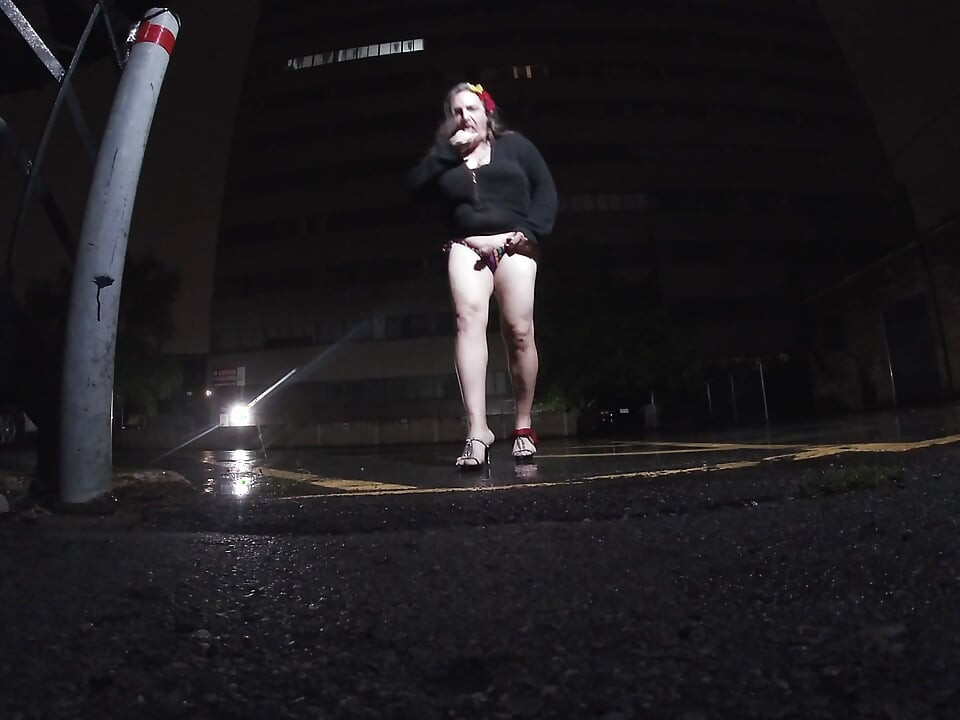Mature sissy CD out in the rain in A parking lot in public masturbation.