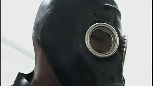 Two guys wearing masks get their large cocks sucked by a hot chick in latex gear