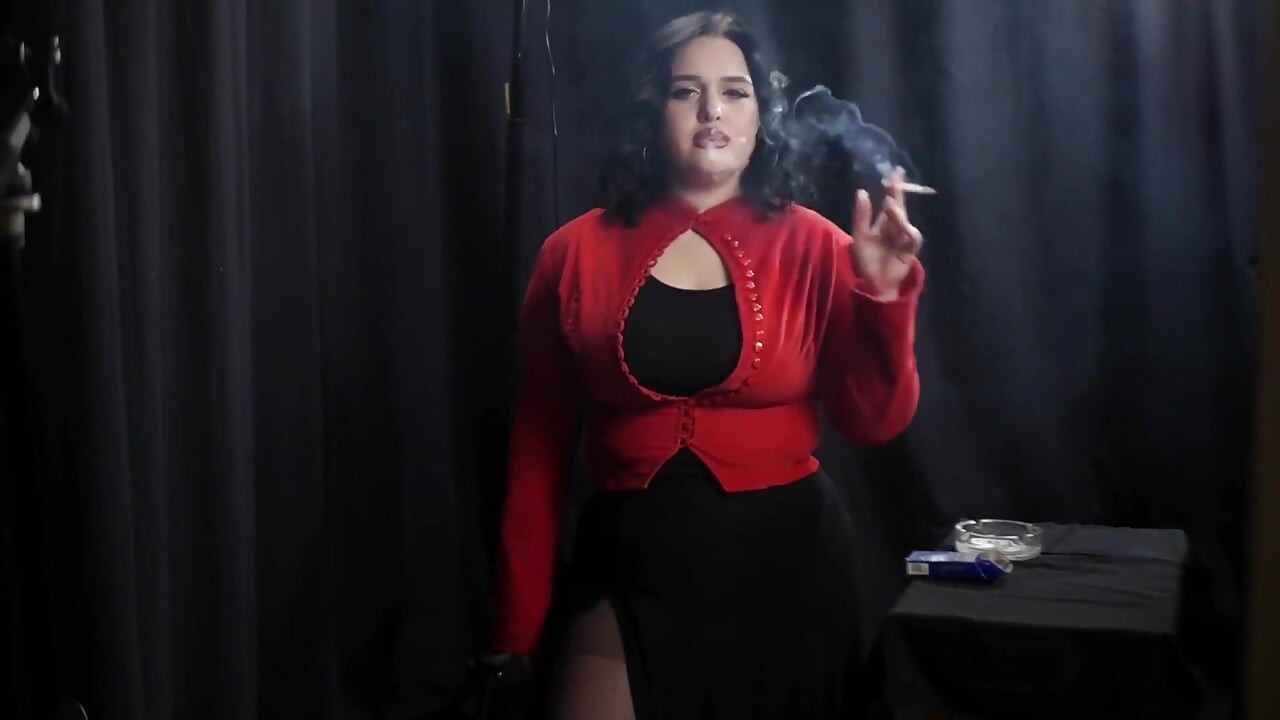 丰满的黑发女郎穿着红色开衣抽烟
