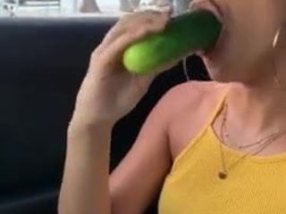 Una mujer comiendo un pepino