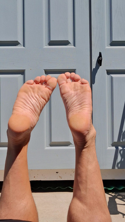 My girlfriend shoots my bare feet while I tan