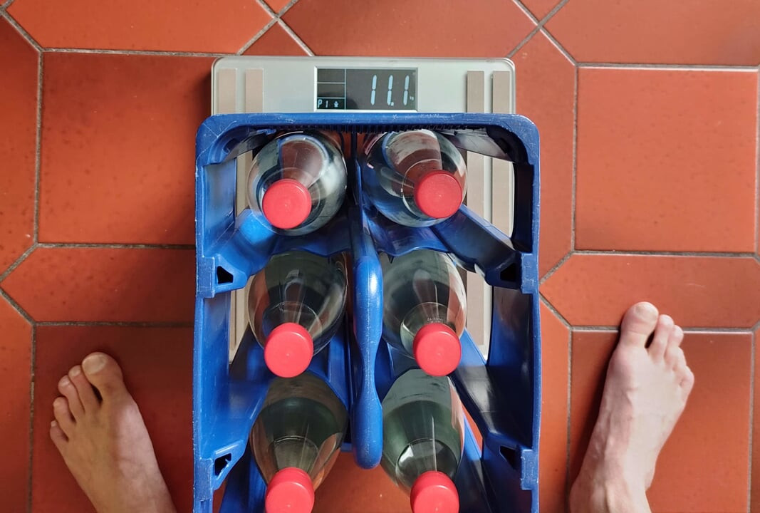 I lift a box of water bottles with my balls. It weights about 11kg.