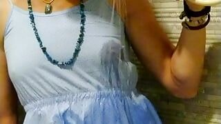 Transgirl wetlook con vestido de verano azul claro en la ducha.