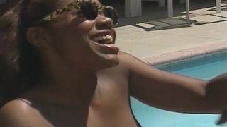 Black babe sucks and rides cock next to a pool