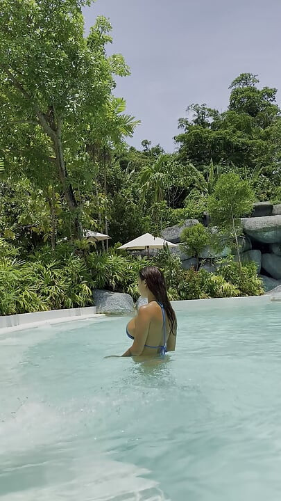 Monika fox in bikini blu nuota in piscina in un posto paradiso