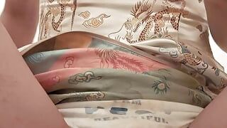 Um homem em um cheongsam se masturba usando calcinha de menina