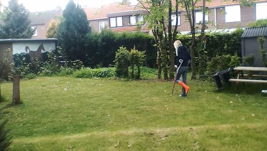 Promenade dans le jardin avec des béquilles et fumer une cigarette à la fin