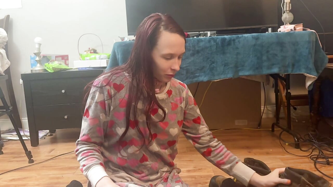 girl takes cares of mans feet after work. she takes off his boots and socks and smells them deeply