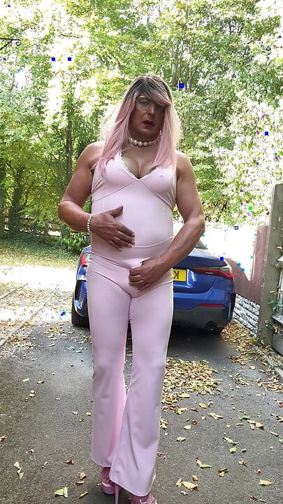 Crossdresser kellycd2022 u ružičastom kombinezonu i štiklama