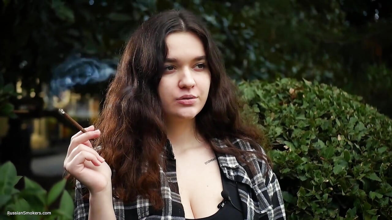 Sød og barmfagre russisk babe ryger cigaret i naturen