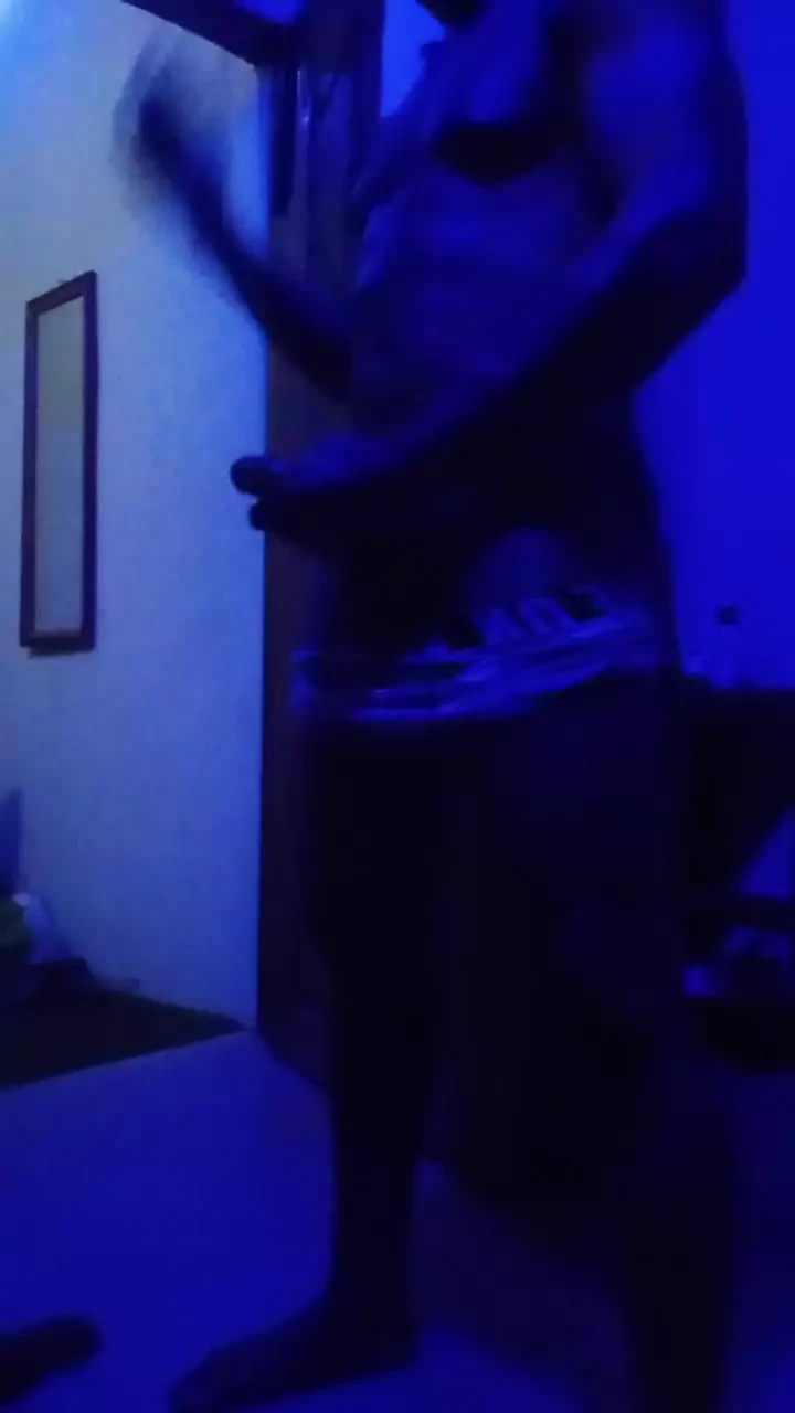 Black muscled guy masturbates in a blue room.