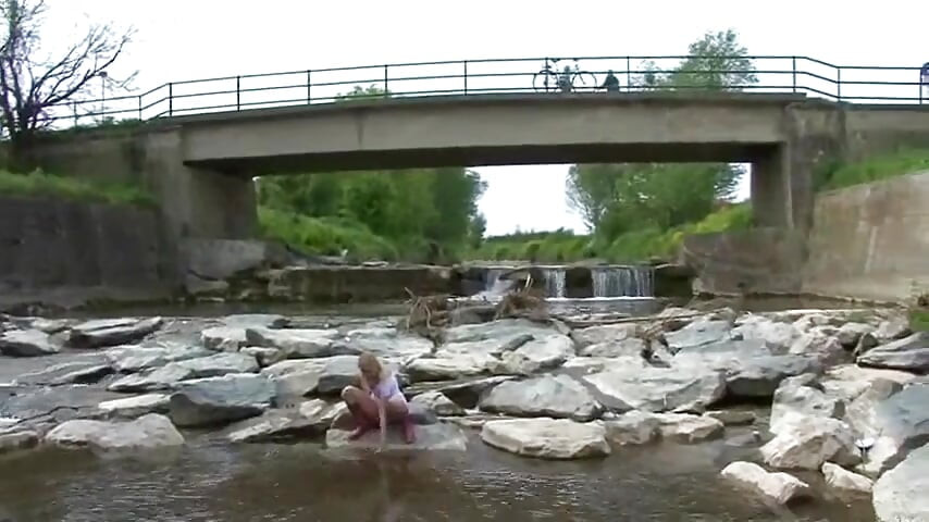 Rubia meando afuera en un río