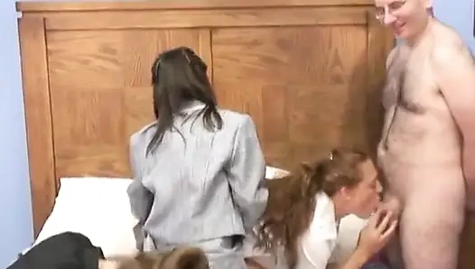 Reife brünette lutscht jungen kerl, während zwei süße studentinnen den alten penis auf einem bett teilen