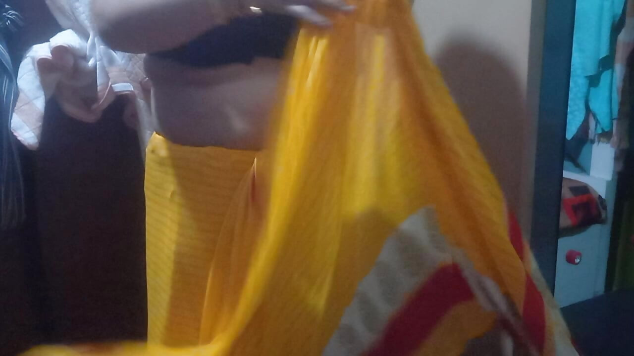 Indian housewife is wearing a yellow saree.