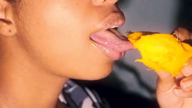 Sexy mouth ebony playing with a mango