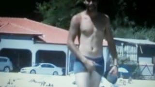 hot guy walking  on beach rubbing his bulge