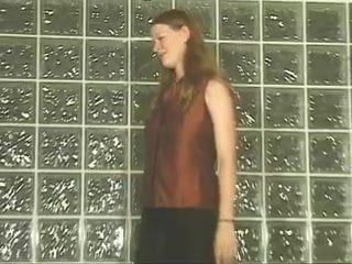 Meisje tegen muur toont haar grote tieten en geschoren poesje