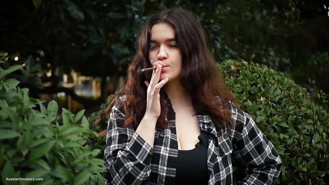 בחורה רוסייה מתוקה וחזה גדול מעשנת סיגריה בטבע