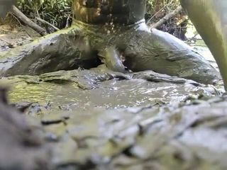 Pria telanjang bermain di lubang lumpur