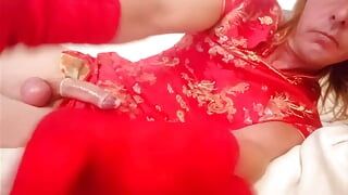 Leatransteen draagt een rood-Aziatische gewaad en vult haar condoom