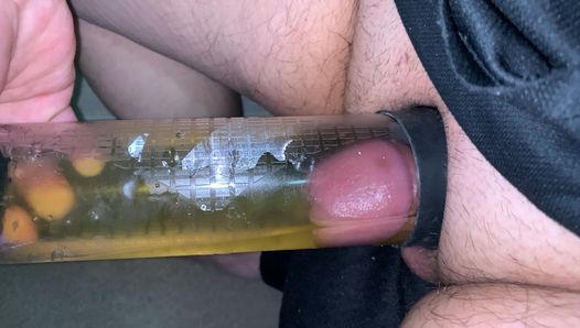 Kleiner Penis pisst in einen Pumpenzylinder