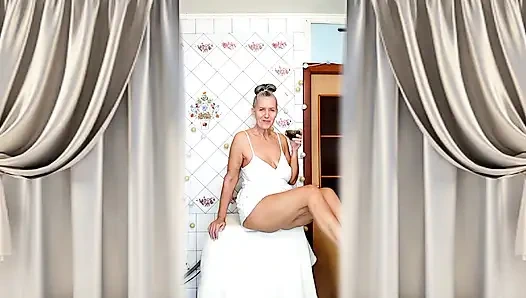 Real home solo of a mature woman in a small cozy kitchen.