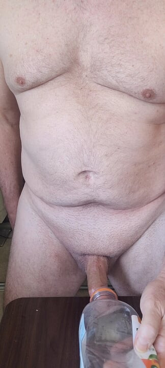 Exhibitionist masturbator testing a new bottle for cock play