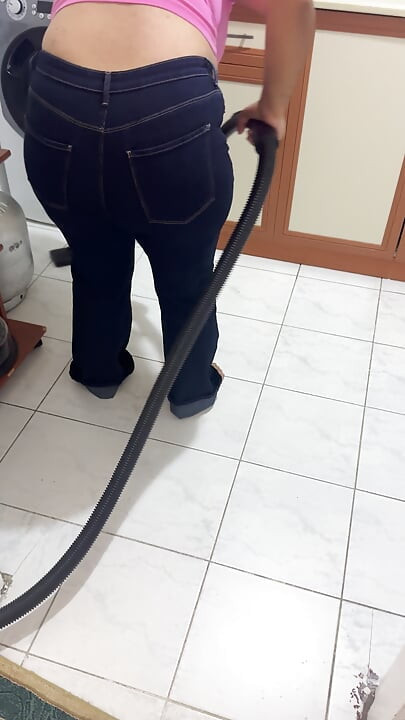 Düzgün vücutlu kadın evi pantolonla temizliyor