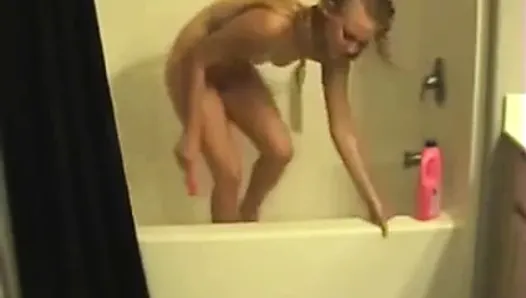 Une blonde mouillée se déshabille et se masturbe dans la baignoire