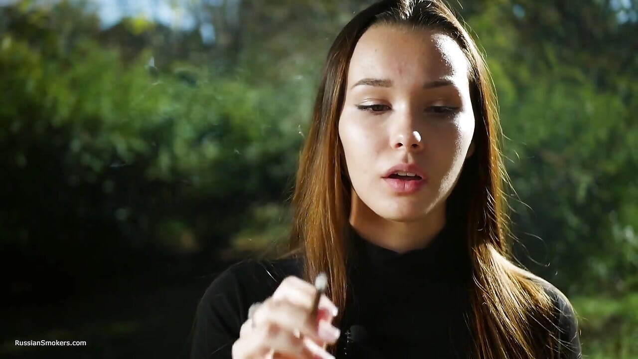 Dulce sensual chica rusa fumando cigarrillo afuera