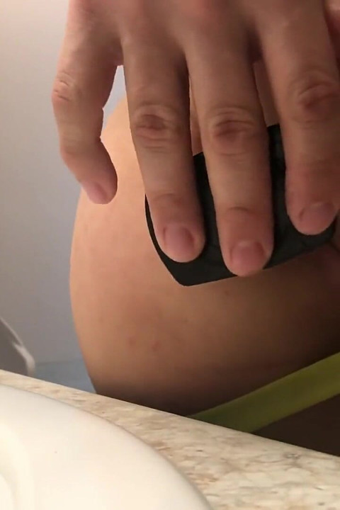 Esticando a bunda raspada com plug anal preto na cinta-caralho