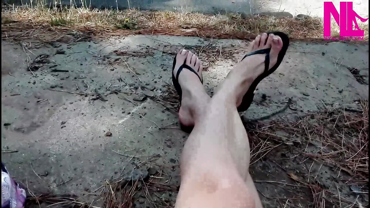 Louca pendurada em meus chinelos pretos de couro em um parque