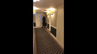 Sandra walking in hotel corridor