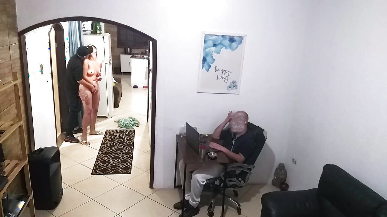 While the husband works, the wife in a towel greets the delivery man.