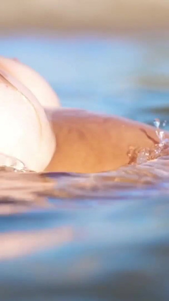 Stunning moment from "Stunning blonde flaunts her big breasts, perfect ass, and gorgeous pussy in a nude beach scene!"