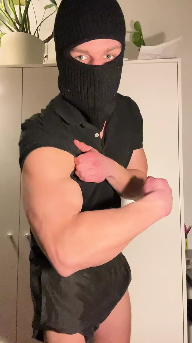 Young muscle hunk strips in balaclava