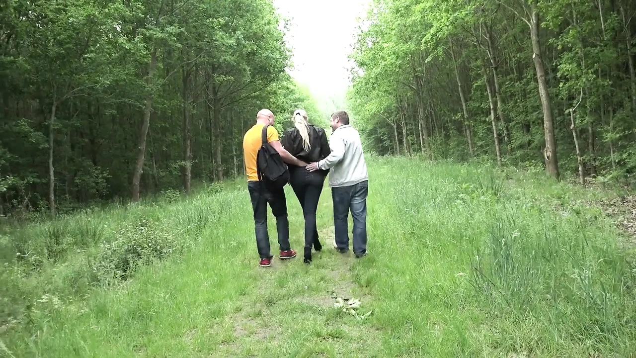 金发女郎吮吸两根鸡巴, 然后在灌木丛中被性交射精