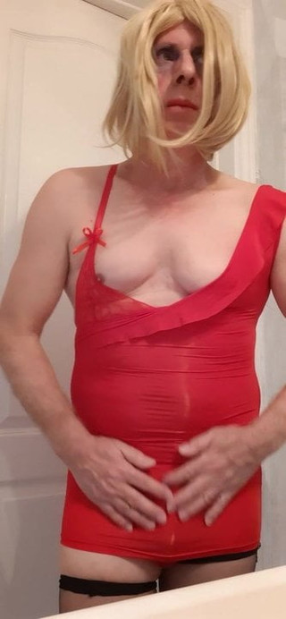 Sissy crossdresser na sobie czerwoną mini sukienkę