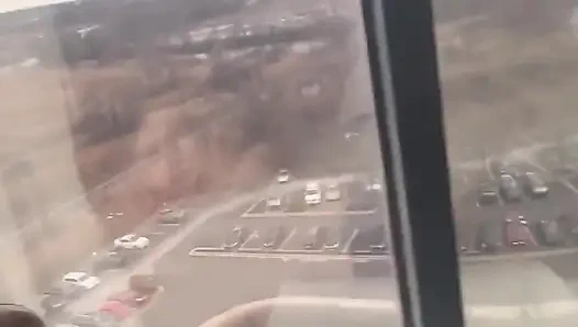 Backshots geben, während sie aus dem 12. Geschichte hotel gucken