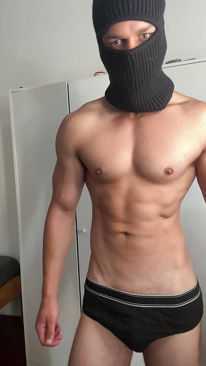 Masked young hunk showing off his muscles