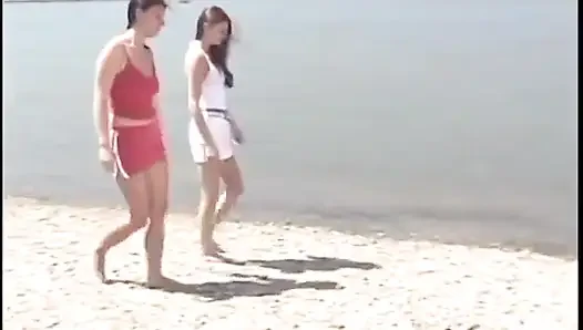 Teen girls are fucking each other with a clear dildo on the beach