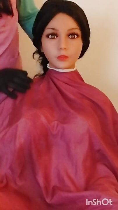 Lindsey en cape de coupe de cheveux, séance de mannequinat avec une poupée sexuelle plantureuse.