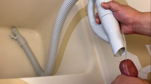 Un gros avec un petit pénis jouit et pisse dans le tuyau d'un aspirateur