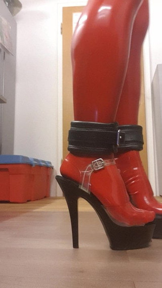 Walk in cuffed feet wearing red latex stockings and heels