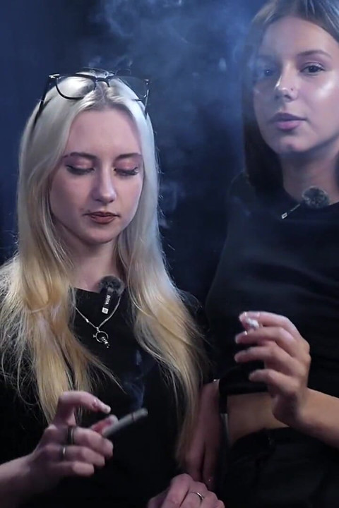 Two Women Smoking Together in a Dark Studio with Soft Blue Lighting