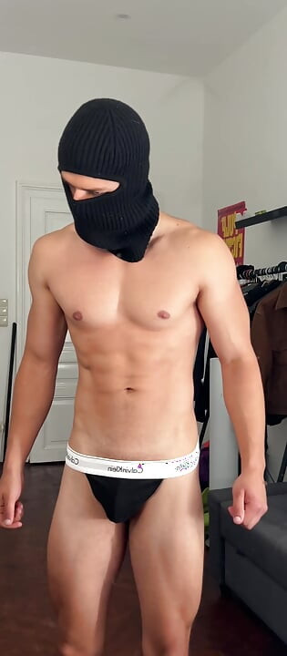 Young hunk flexing his muscles in a tight thong