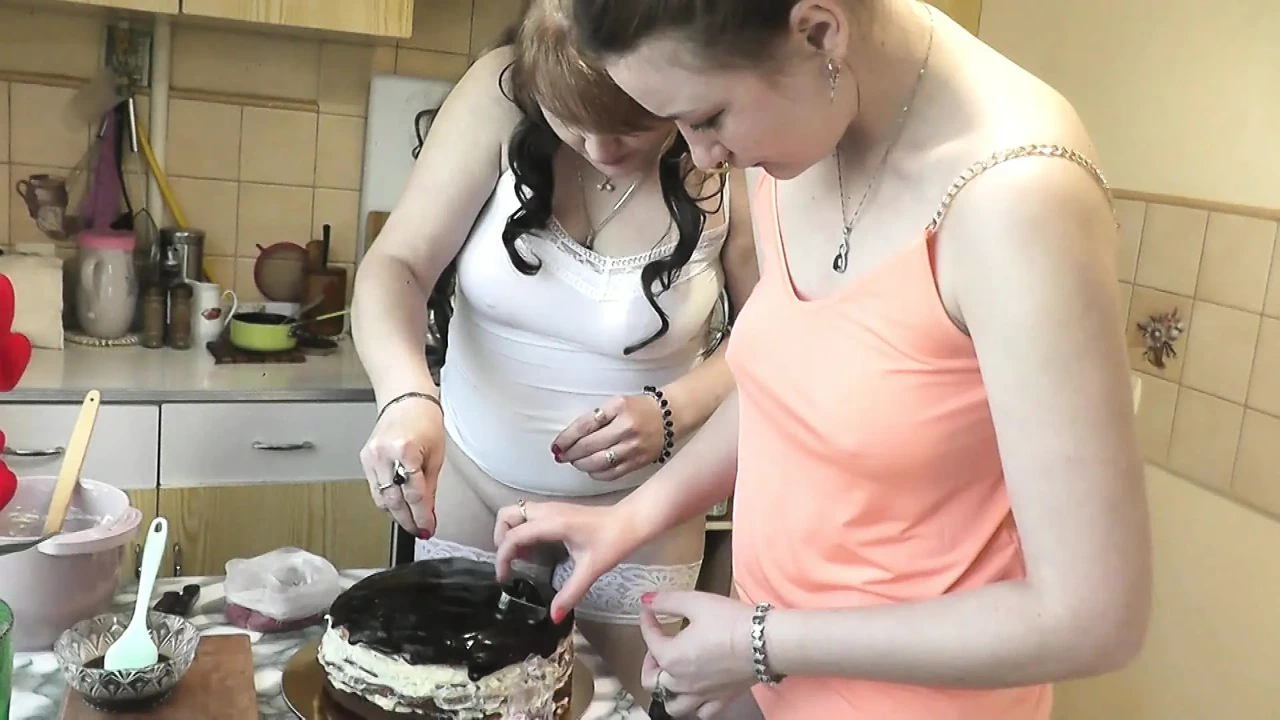 妇女节。熟女和真正的处女穿着短上衣T恤，不穿内裤，为假期制作蛋糕厨房。Girl On Girl Kiss